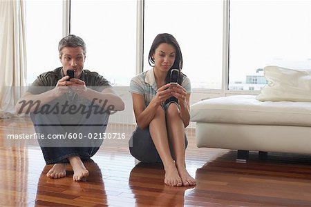 Couple with Cellular Phones in Condominium