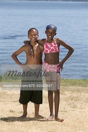 Young boy and girl standing near a lake.