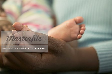 A mother holding her baby daughter's feet.