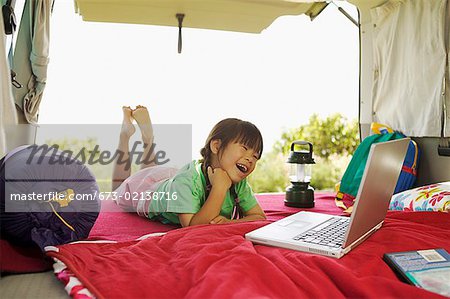 Jeune fille à l'aide de son ordinateur portable en voiture - camping