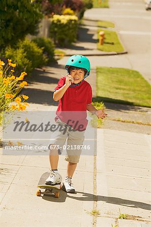 A young skateboarder talking on his mobile phone