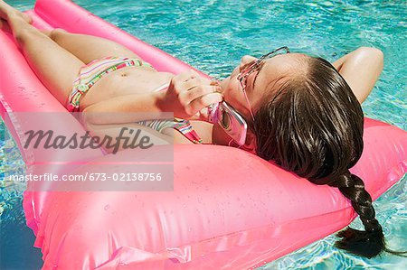 Girl talking on a mobile phone in a pool
