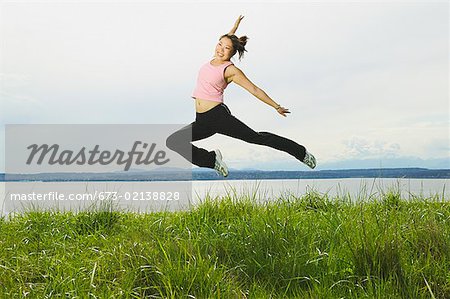 A young woman jumping through the air