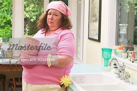 Femme mécontente de laver la vaisselle