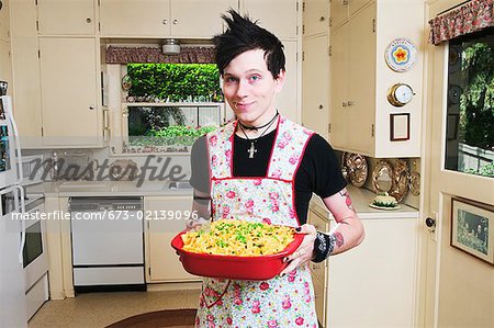 Homme dans la cuisine tenant une cocotte