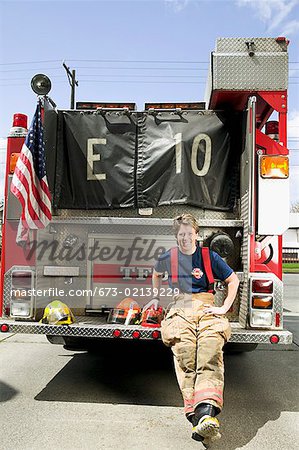 Female firefighter sitting on a fire truck