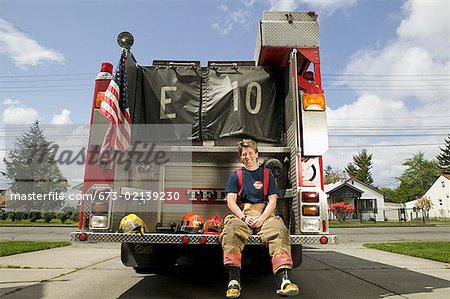 Pompier femme assise sur un camion de pompier