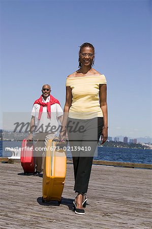 Couple sur le quai en tirant des bagages