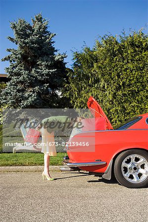 Woman looking in trunk of car
