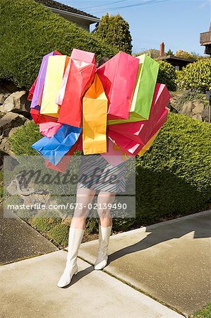Woman carrying many shopping bags