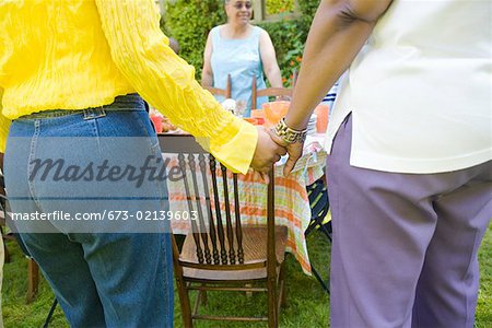 Women holding hands at picnic