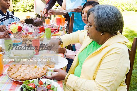 Woman selecting desert at picnic