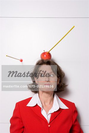 Tir une pomme sur la tête de femme d'affaires
