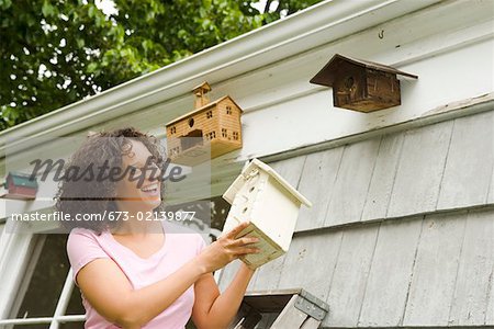 Smiling woman adding to birdhouse collection