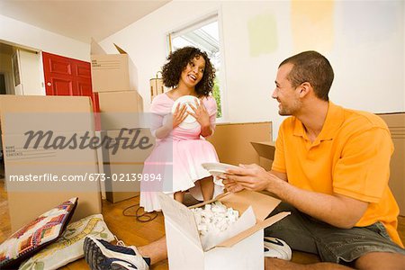 Couple unpacking dishes in new home