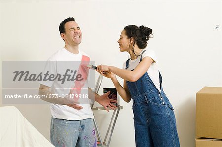 Woman painting on man's shirt