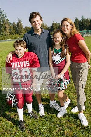 Football player and cheerleader with parents