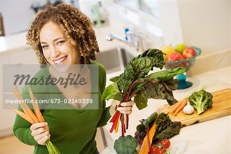 Portrait de femme avec des légumes dans la cuisine