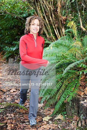 Femme jogging sur la piste forestière