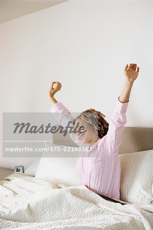 Frau erwacht und stretching im Bett