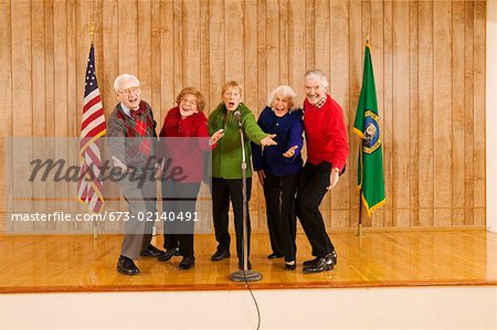 Personnes âgées enthousiastes, chantant sur scène