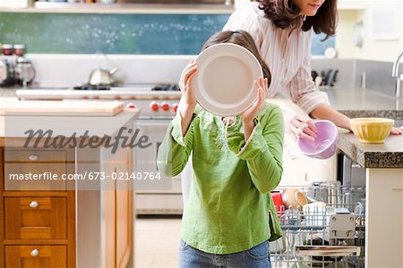 Mom and daughter unloading dishwasher