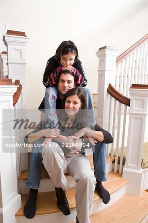 Portrait of couple with daughter on stairs
