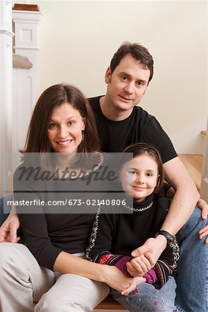 Portrait of couple holding hands with daughter