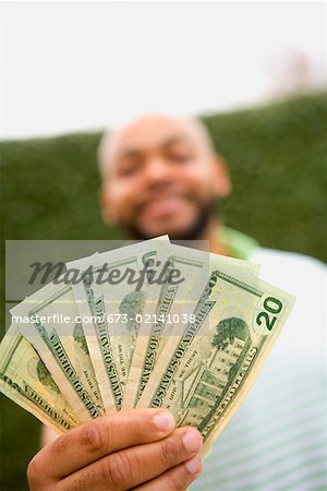 Man holding twenty dollar bills