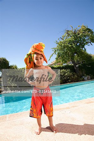 Young boy wearing towel turban by pool