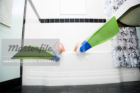 Pacific Islander, Asian woman wearing flippers in bathtub