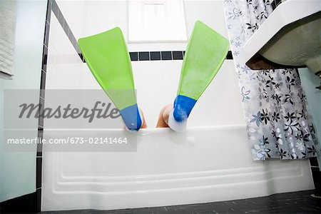 Pacific Islander, Asian woman wearing flippers in bathtub