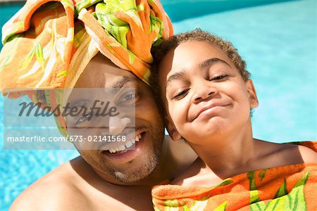 Father and son drying off by pool