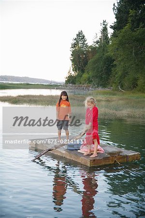 Junge Mädchen auf einem Floß in See Rudern