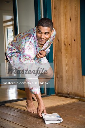 Man picking up newspaper from front porch