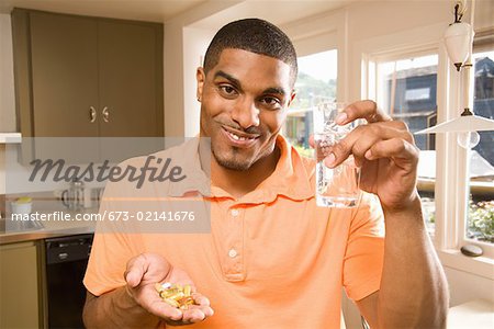 Homme qui prend une poignée de pilules