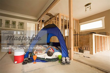 Couple camping in their unfinished living room