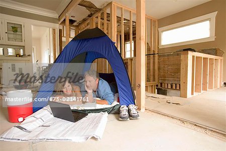 Couple camping in their unfinished living room