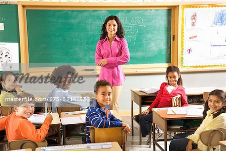 Portrait of female teacher and students in classroom