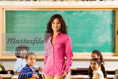 Portrait of female teacher and students in classroom