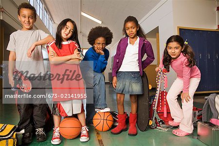 Group of students with sports equipment in hallway