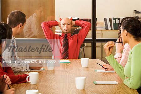 Businessman with devil horns at meeting