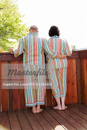 Couple standing on patio in matching pajamas