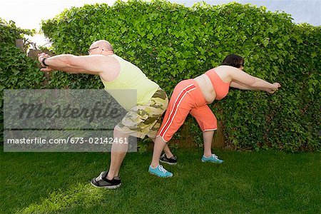 Couple stretching in backyard