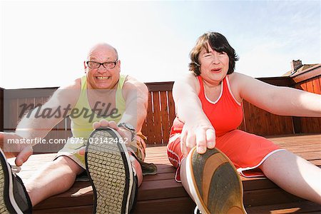 Couple stretching on patio