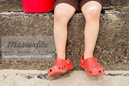 Close up of young boy’s legs on steps