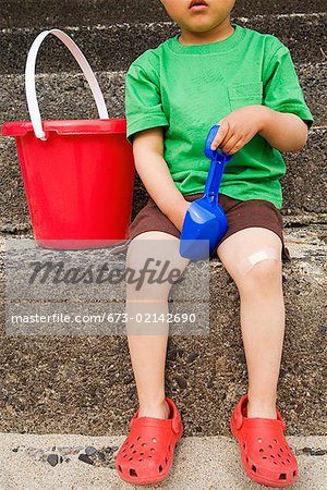 Young boy holding shovel and bucket