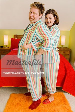 Couple wearing matching pajamas in bedroom