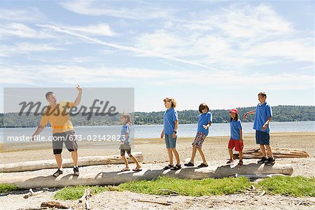 Male camp counselor with children at beach