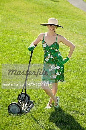 Woman leaning on push lawn mower